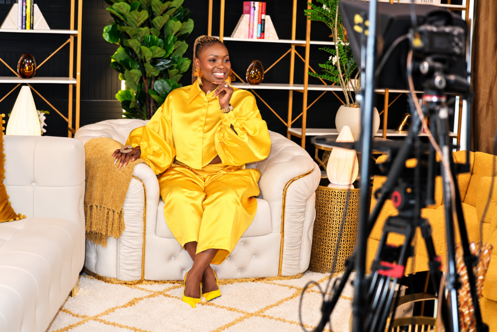 WOMAN puting on gold dress sitting on a couch