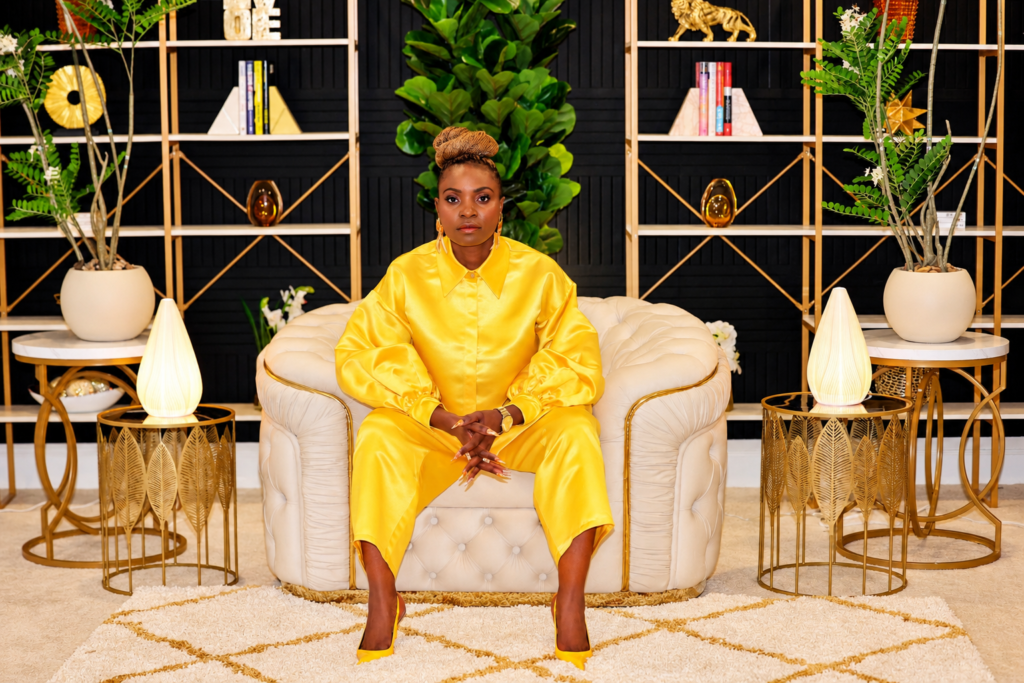 WOMAN putting on gold dress sitting on a couch